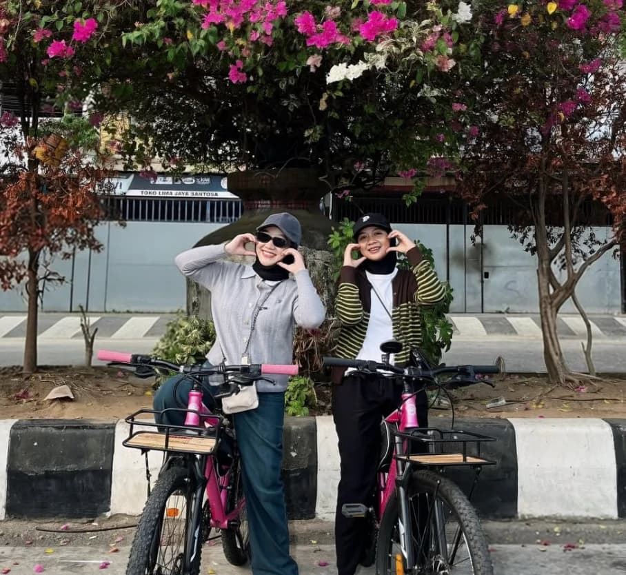 Dua penyewa berpose dengan sepeda NgayuhGO!